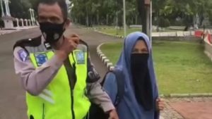 wanita bercadar bawa senjata api di depan Istana